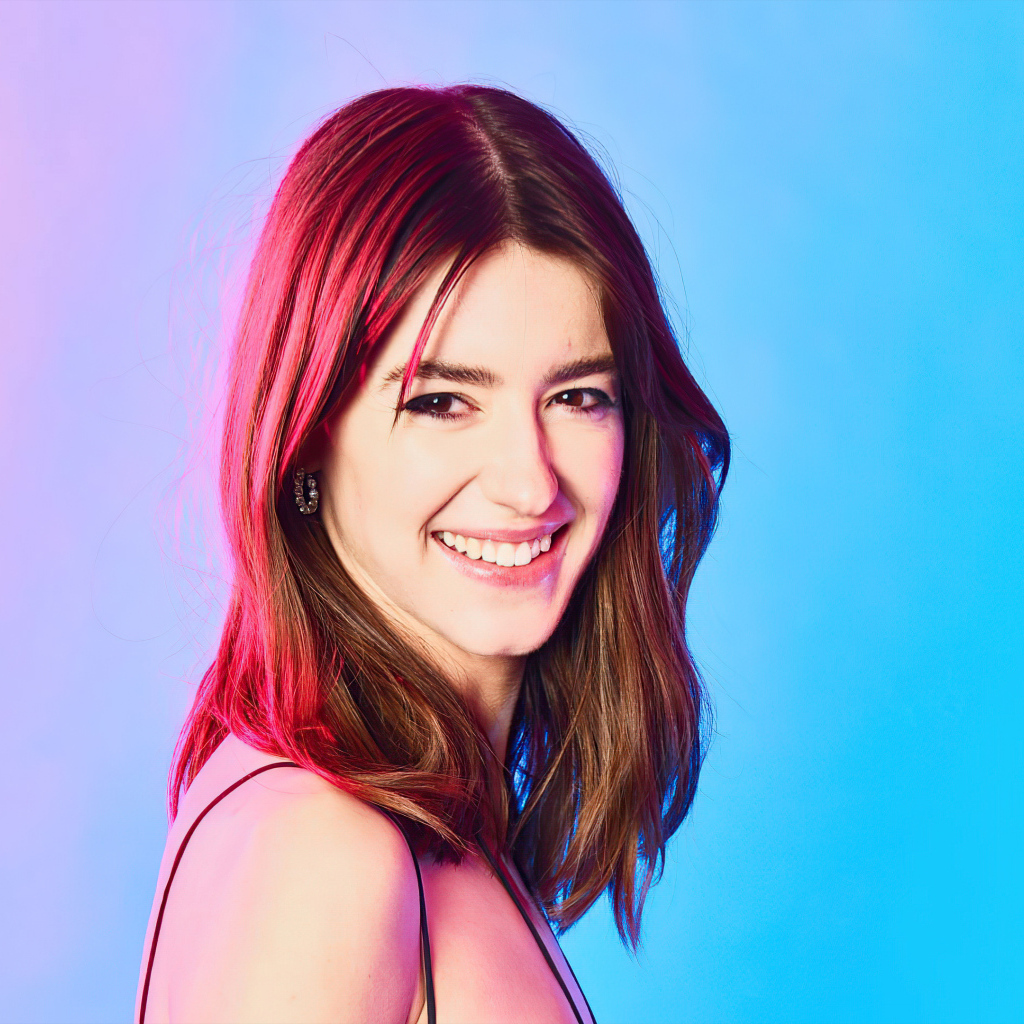 Улыбающаяся девушка Дейзи Эдгар-Джонс на голубом фоне