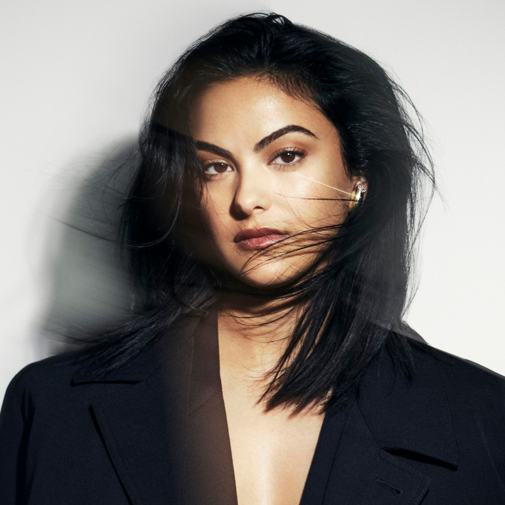 Стильная актриса Камила Мендес в черном пиджаке на сером фоне