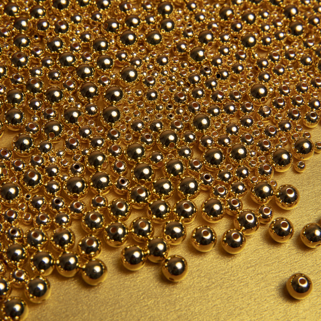 Много золотых бусин на желтом фоне