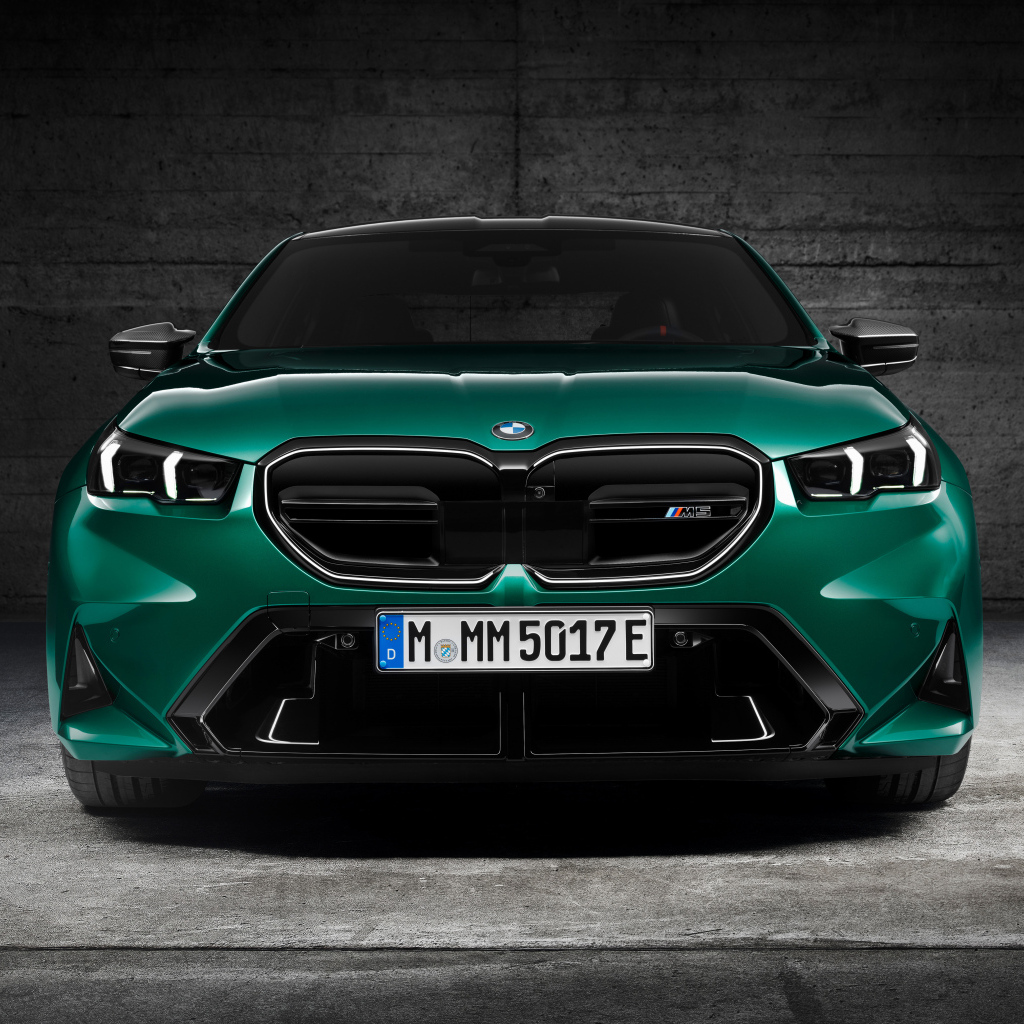 Зеленый автомобиль BMW M5 2024  года вид спереди