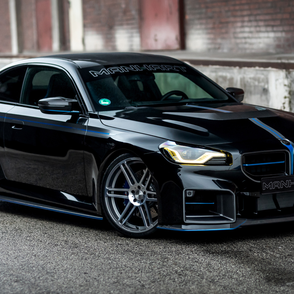 Черный автомобиль BMW M2 Manhart MH2 560 на сером фоне в городе
