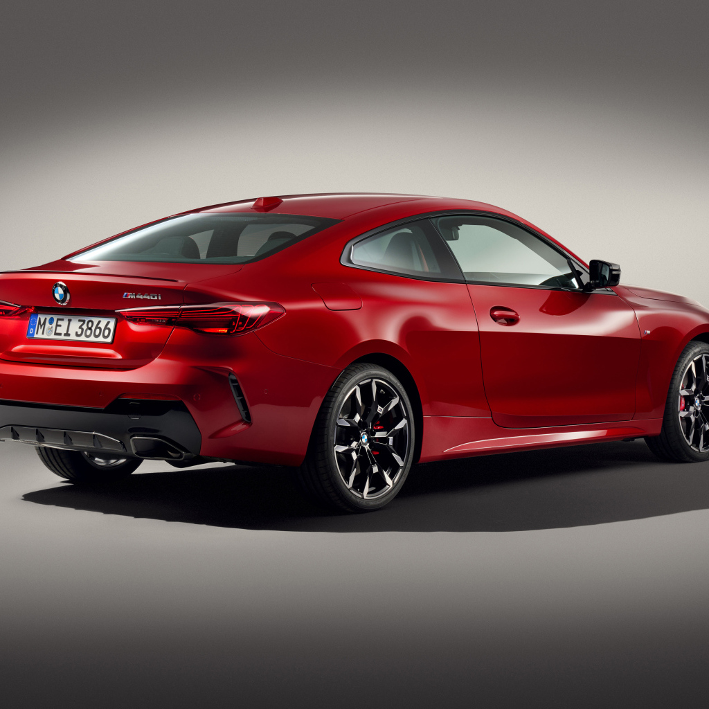 Красный автомобиль BMW M440i XDrive Coupé 2024 года на сером фоне