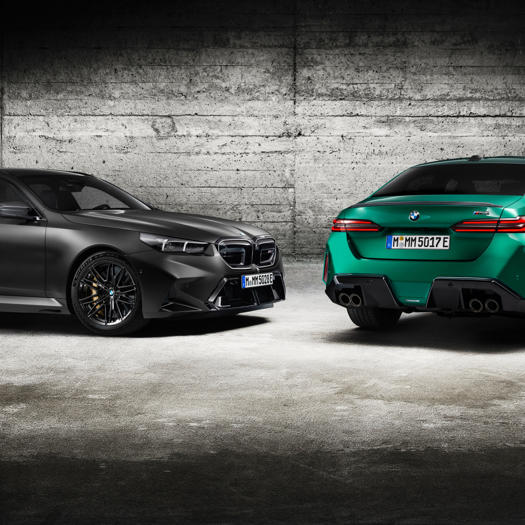 Два автомобиля BMW M5 2024 года на фоне серой стены