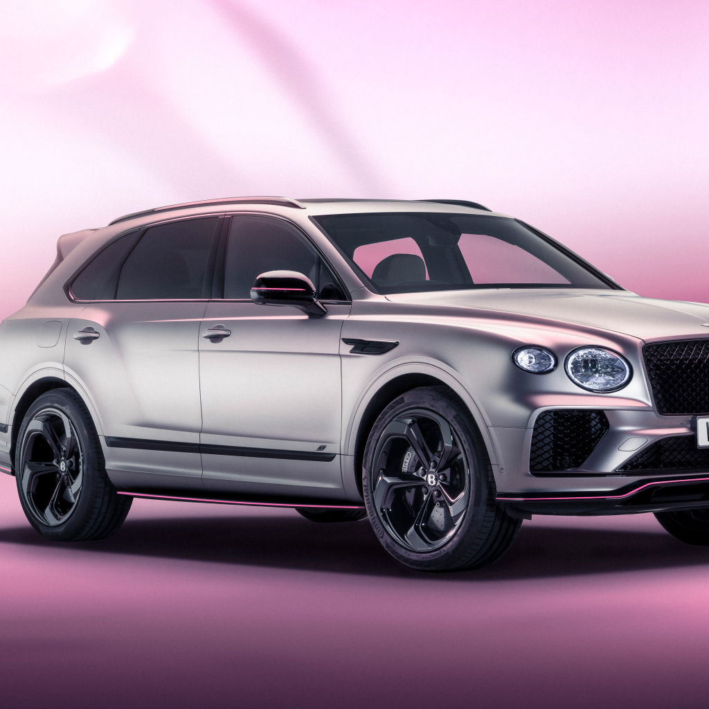 Серебристый автомобиль Bentley Bentayga V8 S Curated By Mulliner 2024 года на розовом фоне