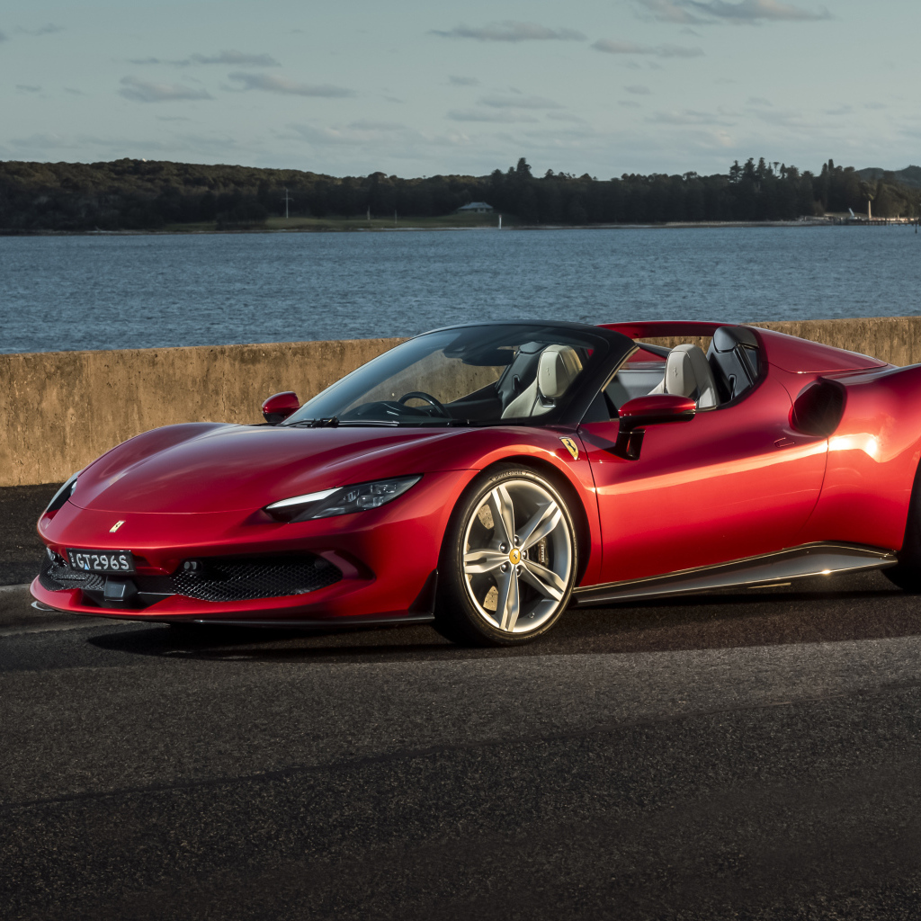 Красный автомобиль Ferrari 296 GTS у реки.