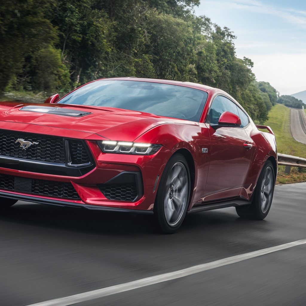 Красный автомобиль  Ford Mustang GT Performance 2024  года на дороге