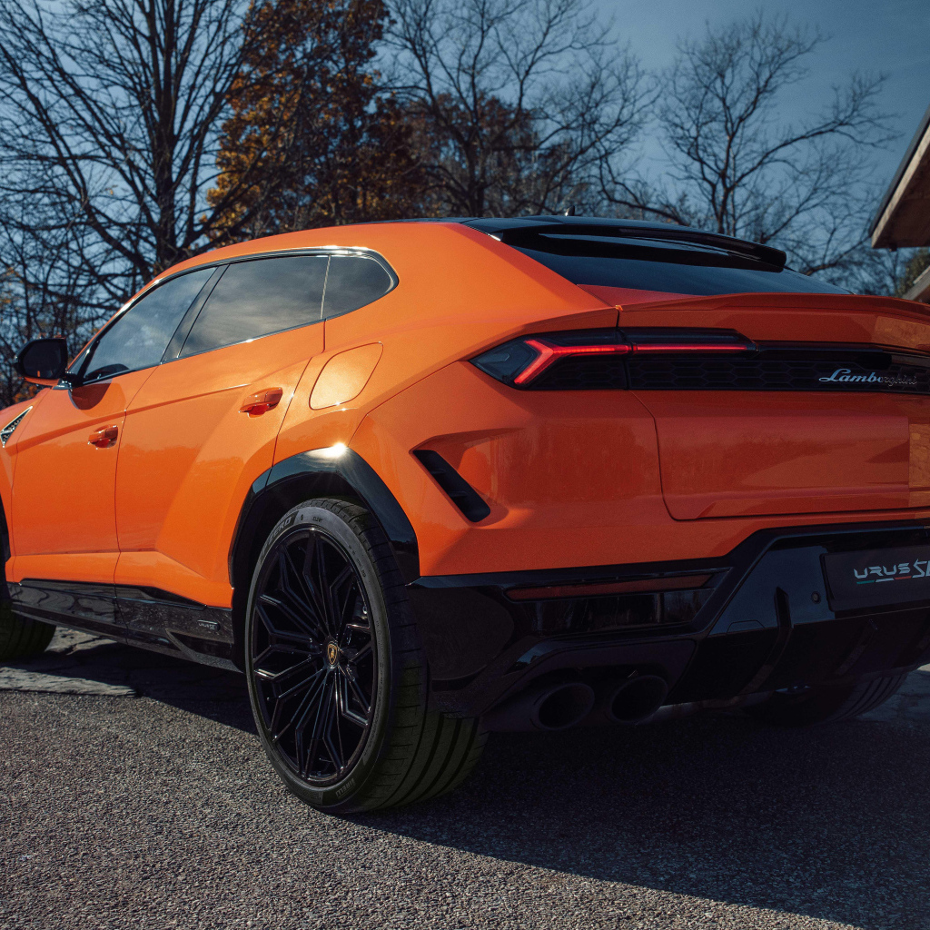 Вид сзади на оранжевый внедорожник Lamborghini Urus SE Plug-In Hybrid