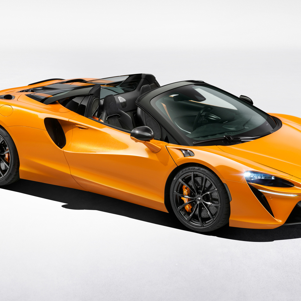 Оранжевый автомобиль McLaren Artura Spider на сером фоне