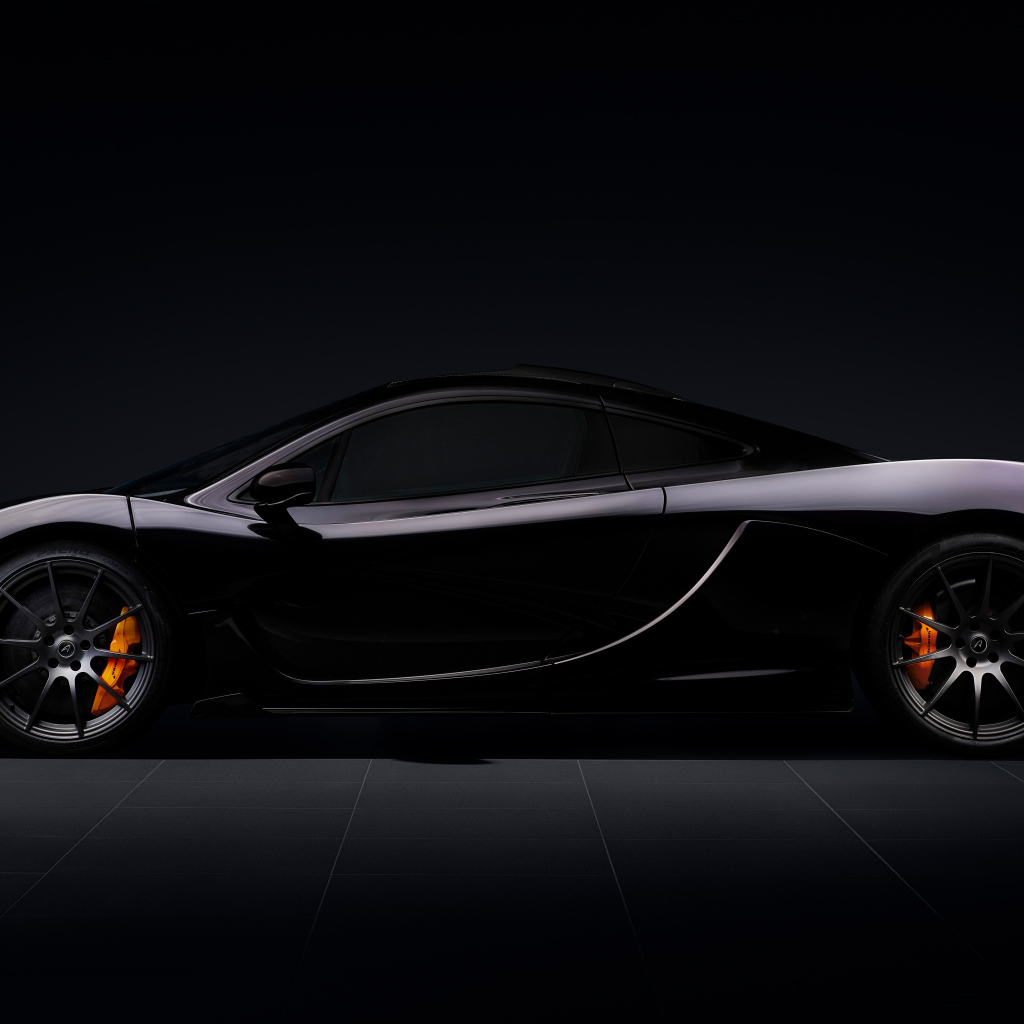 Вид сбоку на автомобиль McLaren P1 на черном фоне