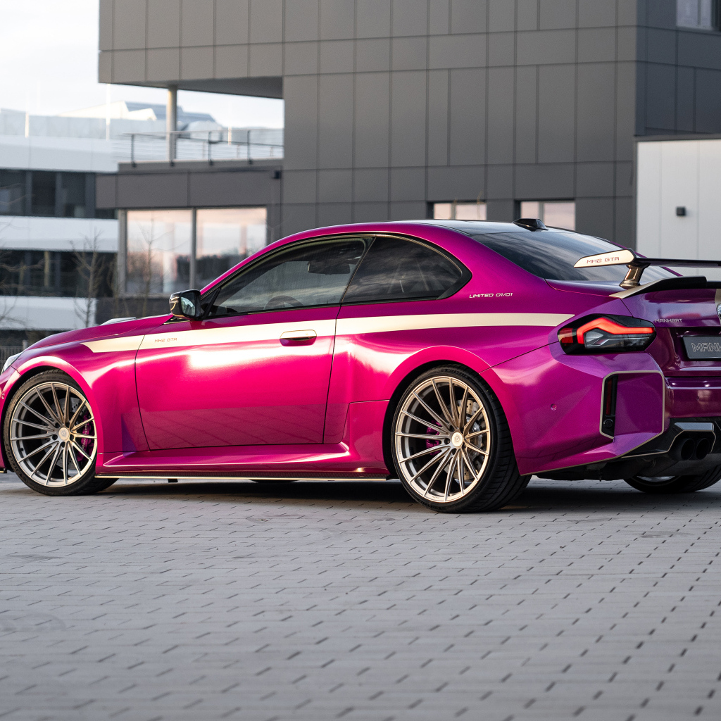 Вид сзади на розовый автомобиль Manhart MH2 GTR II 2024 года