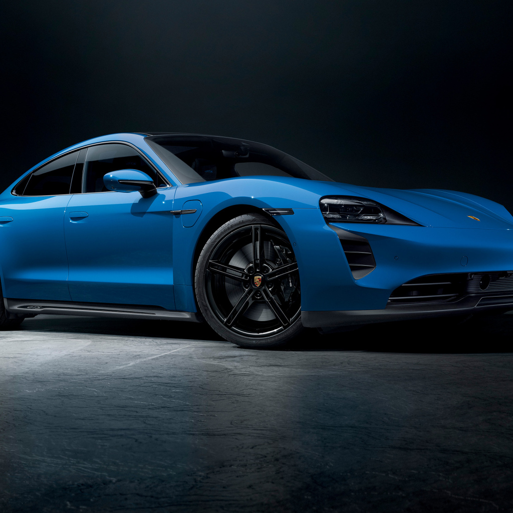 Синий автомобиль Porsche Taycan GTS на черном фоне