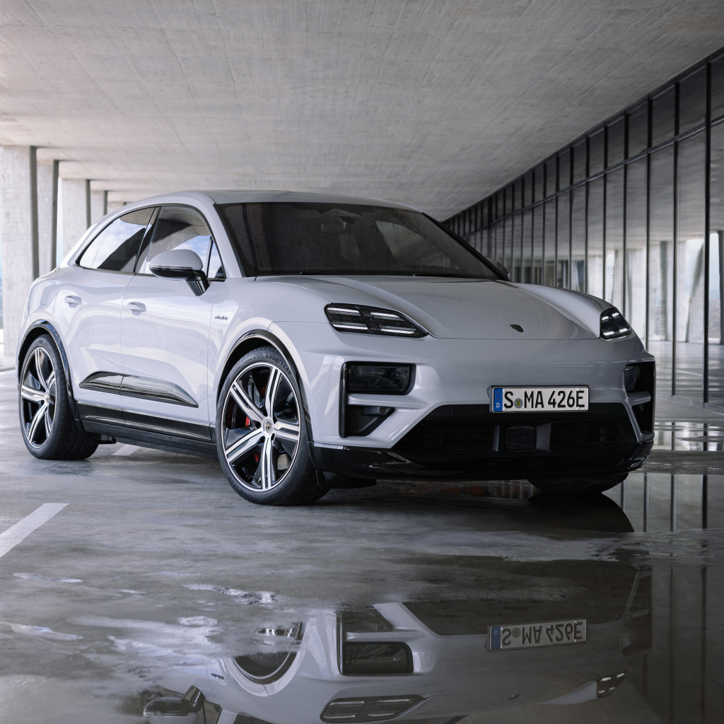 Большой Porsche Macan Turbo 2024 года у здания