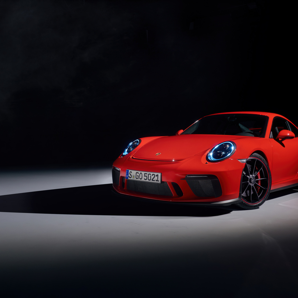 Красный автомобиль Porsche 911 GT3 на черном фоне