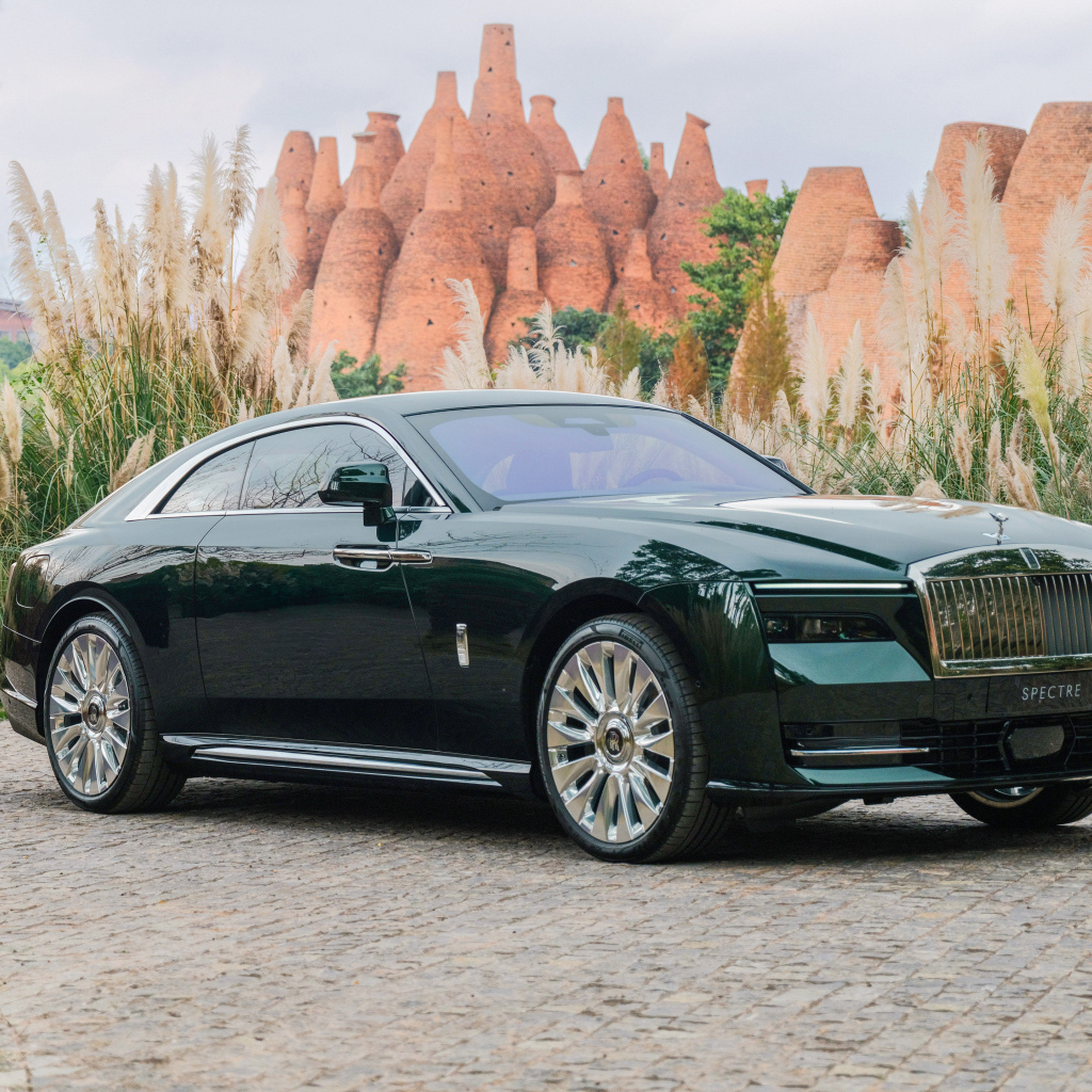 Дорогой зеленый автомобиль Rolls-Royce Spectre