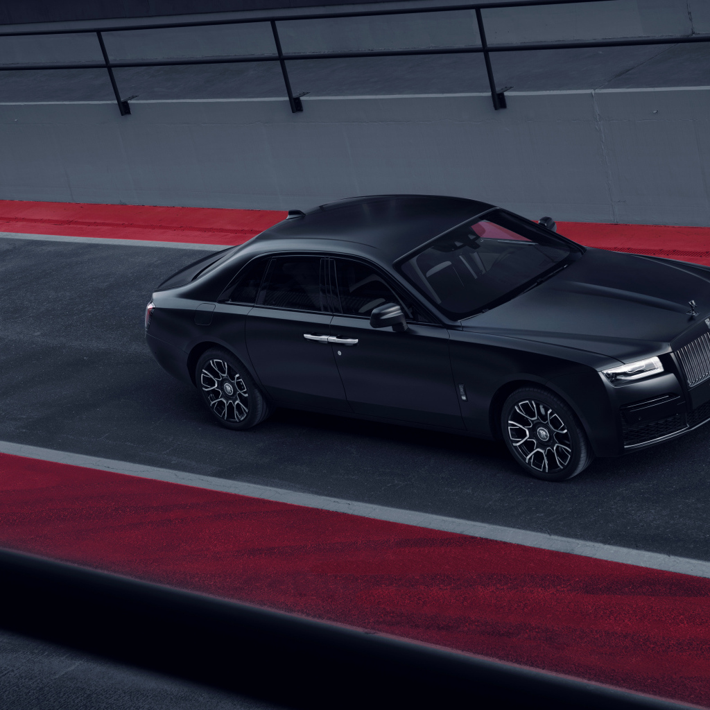 Черный автомобиль Rolls-Royce Black Badge Ghost на дороге