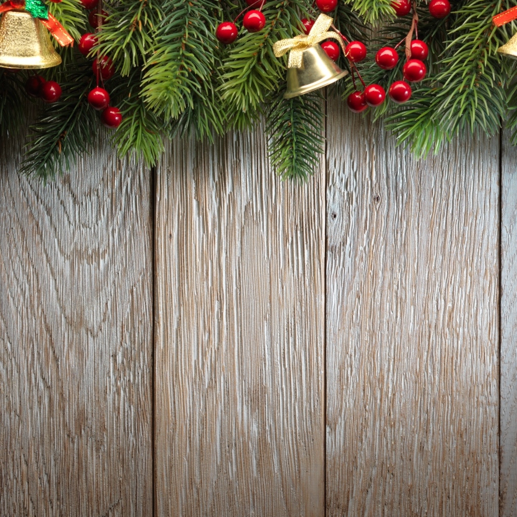 Деревянный новогодний фон с еловой веткой и колокольчиками