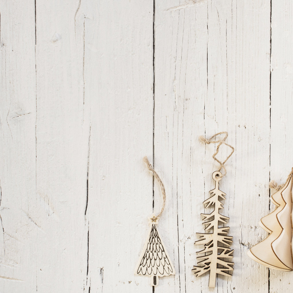 Деревянные елочные украшения  на белом деревянном фоне