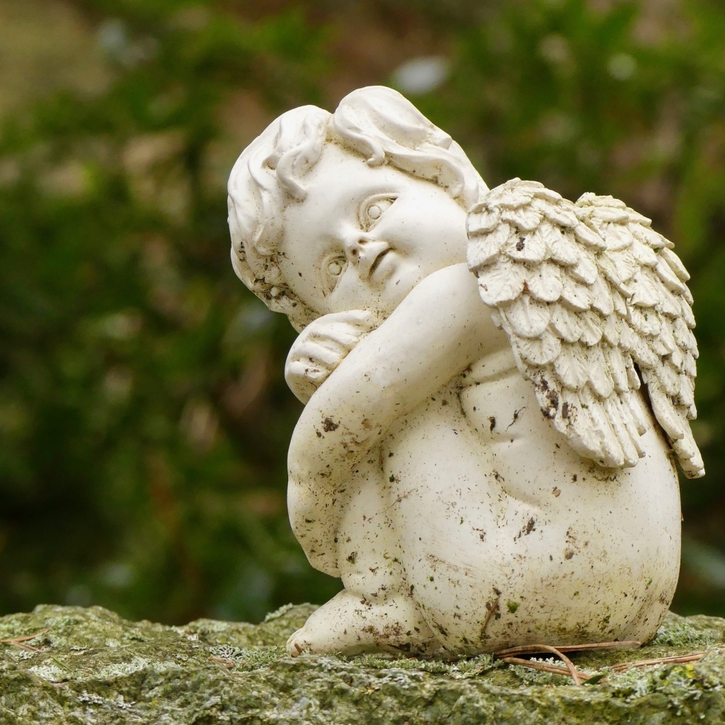 Статуэтка ангела стоит на камне