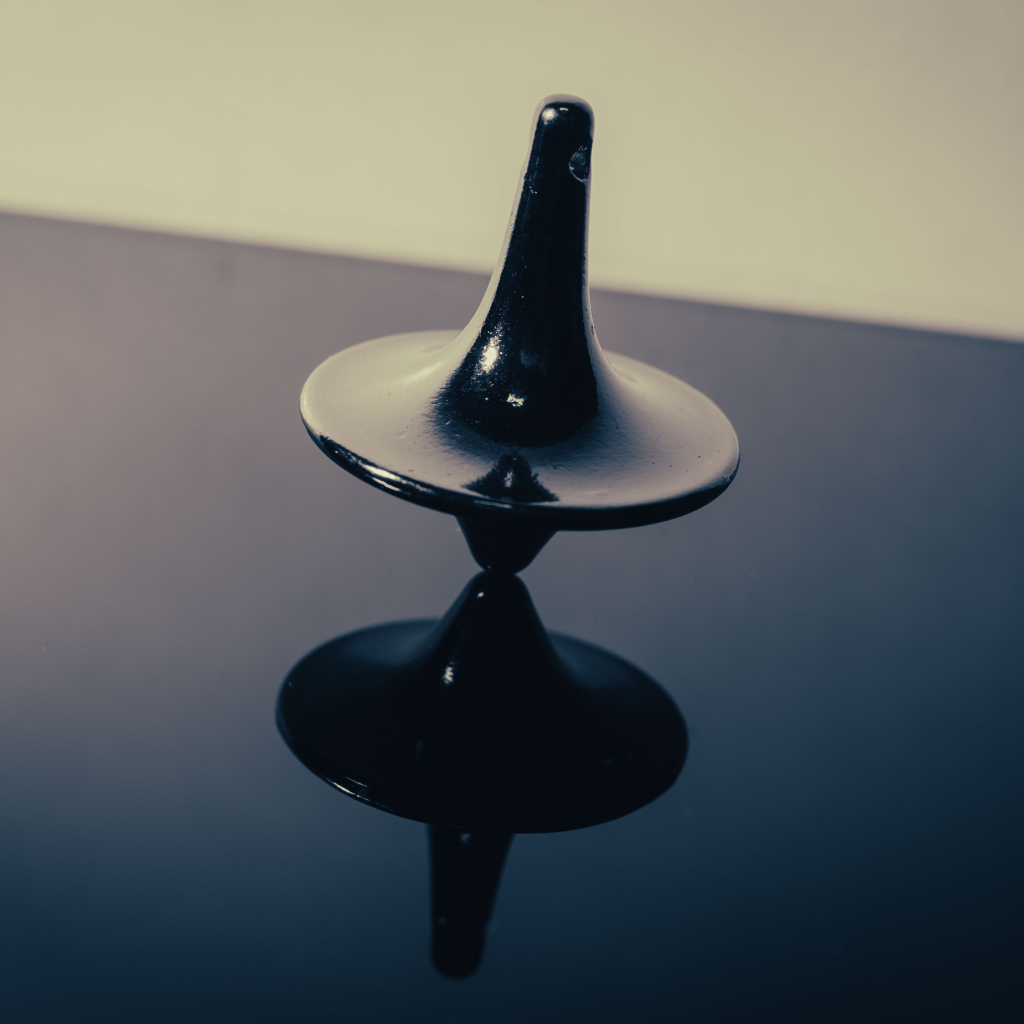 Черный волчок на ровной поверхности