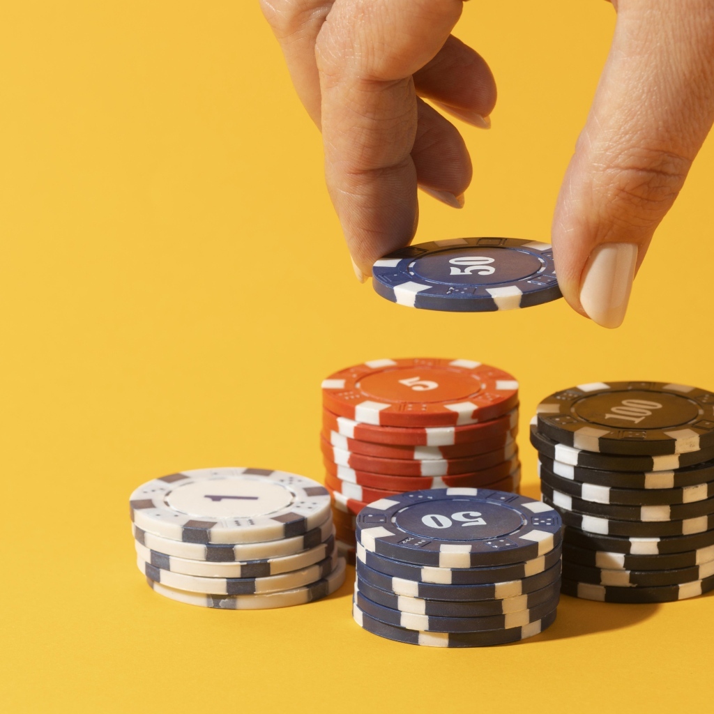 Фишки для казино с рукой на желтом фоне