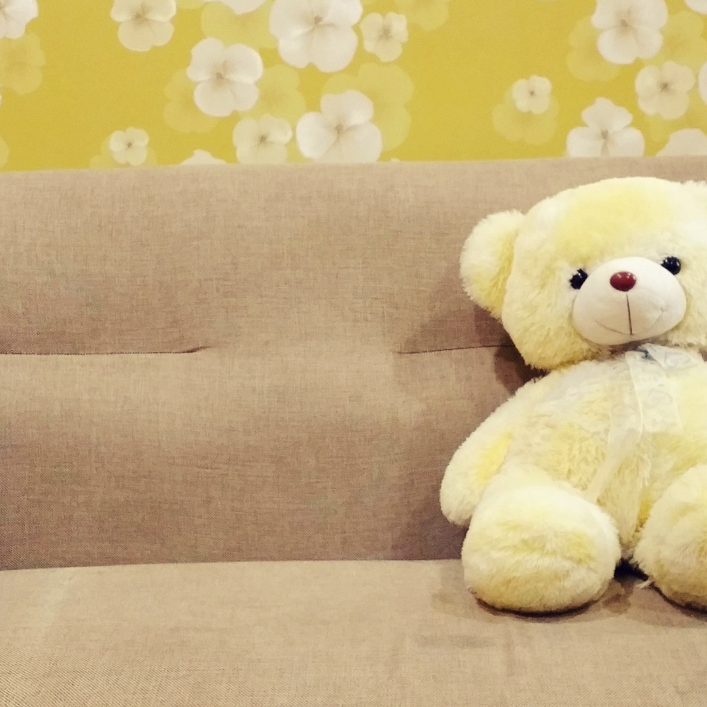 Милый игрушечный медведь на диване