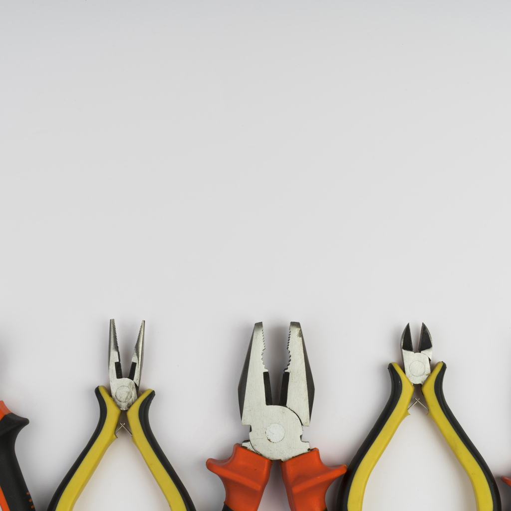 Разные плоскогубцы на сером фоне