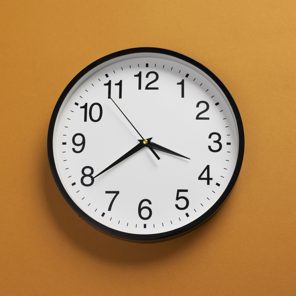 Большие круглые часы на желтом фоне