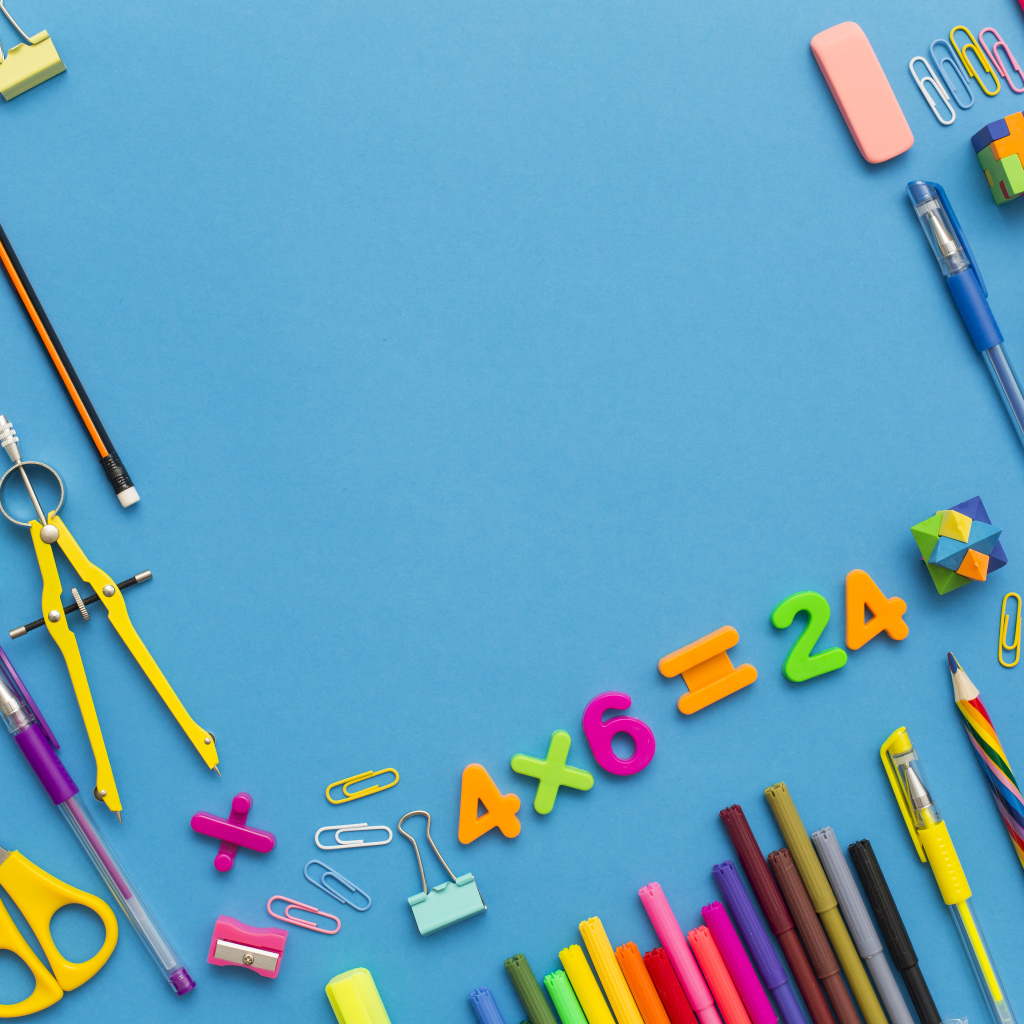 Много разных канцелярских предметов на голубом столе