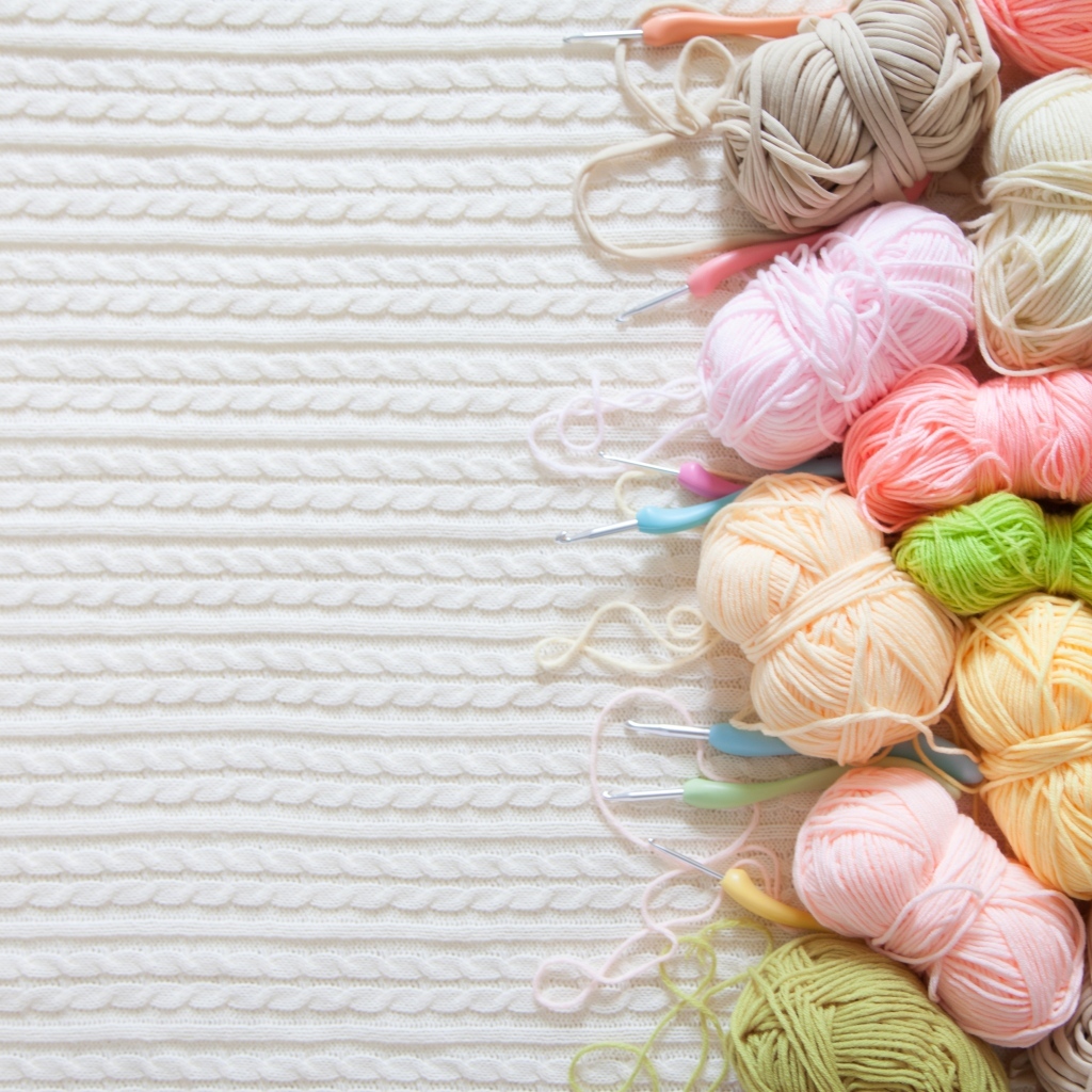 Разноцветная пряжа для вязания на белом трикотажном полотне