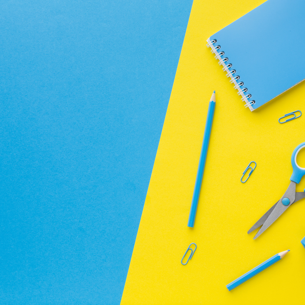 Блокнот, степлер, калькулятор, карандаш и ножницы на голубо-желтом фоне