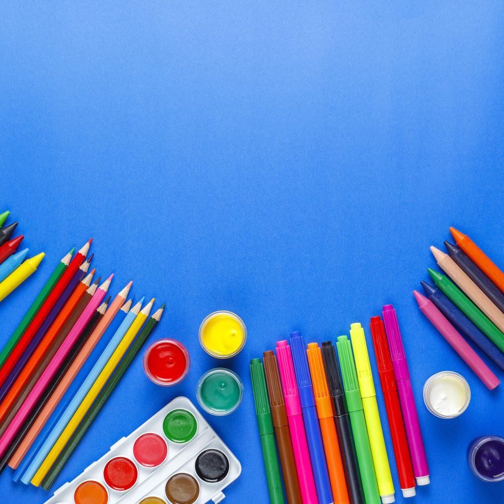 Карандаши, краски, фломастеры и кисти на голубом фоне