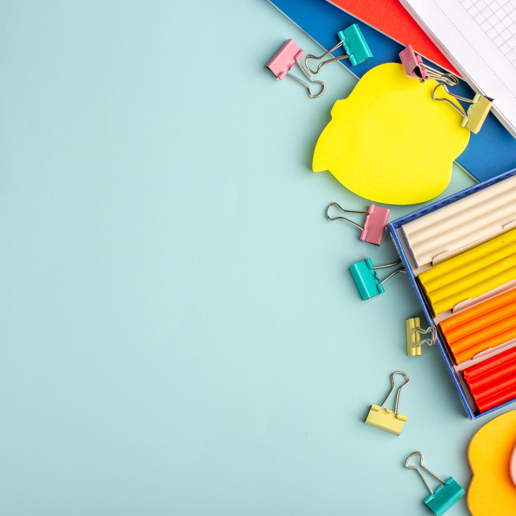 Пластилин на голубом фоне со скрепками и блокнотами