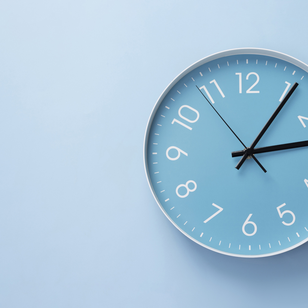 Круглые часы на голубом фоне крупным планом