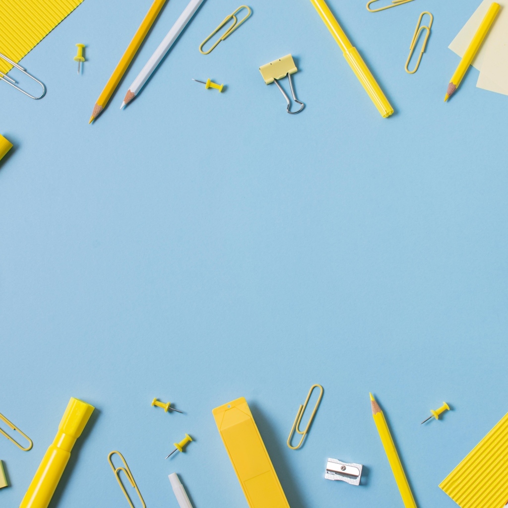Желтые канцелярские предметы на голубом столе