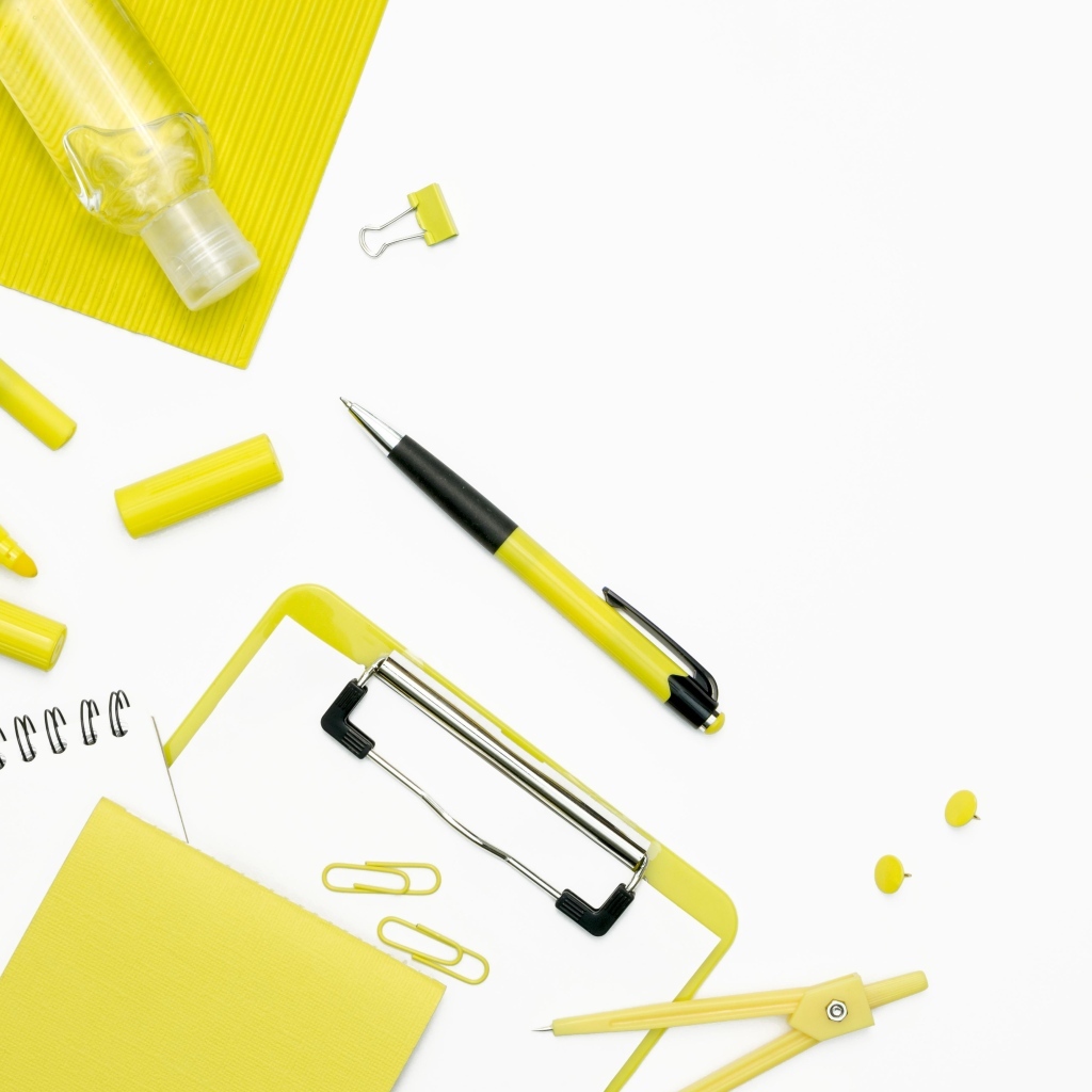 Желтые канцелярские предметы на белом фоне