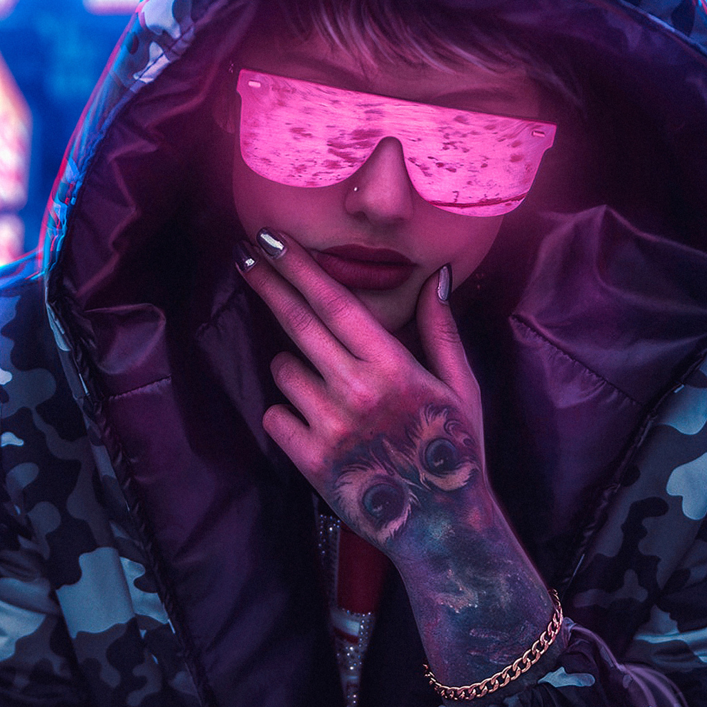 Девушка в неоновых очках с татуировкой на руке