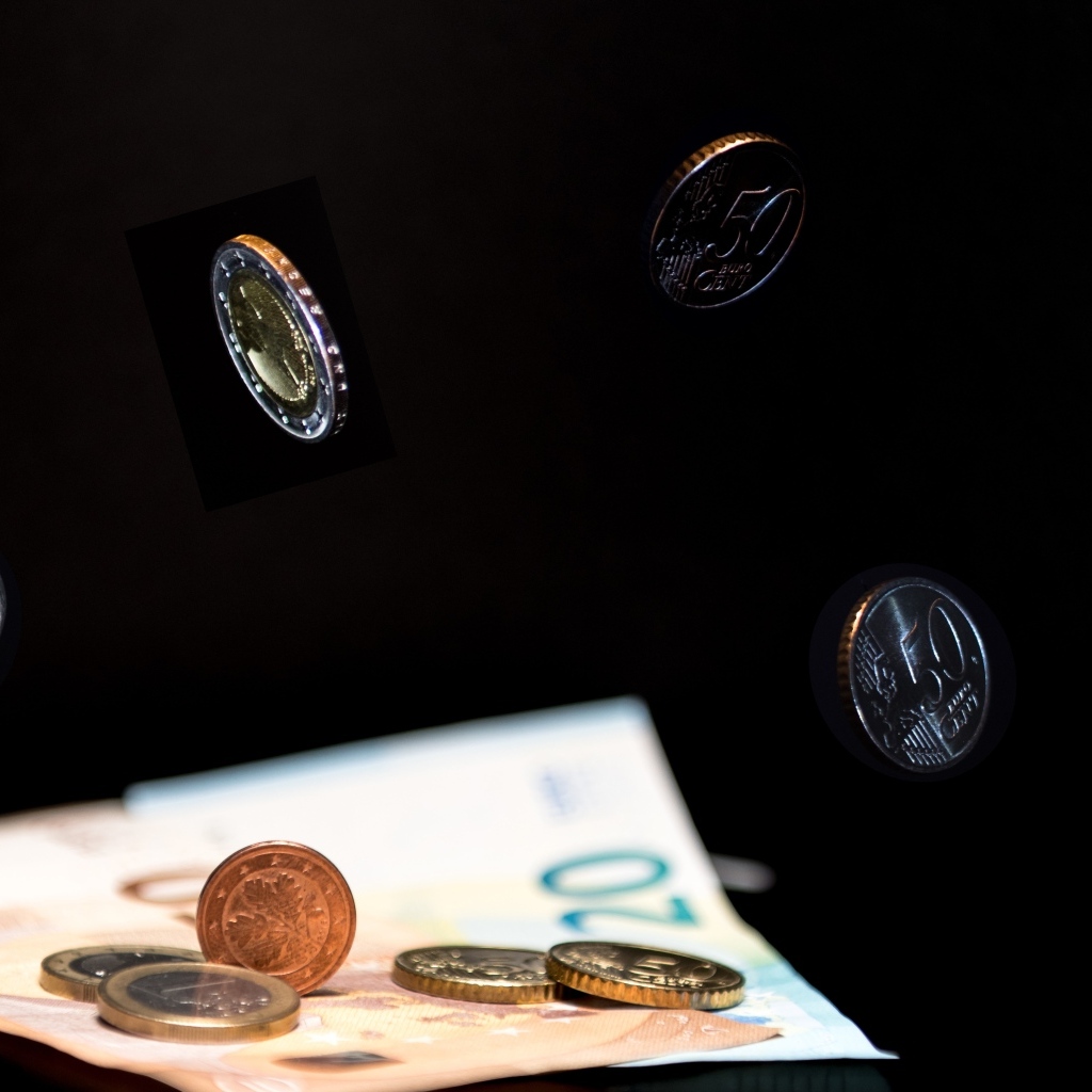 Купюры с монетами на черном фоне