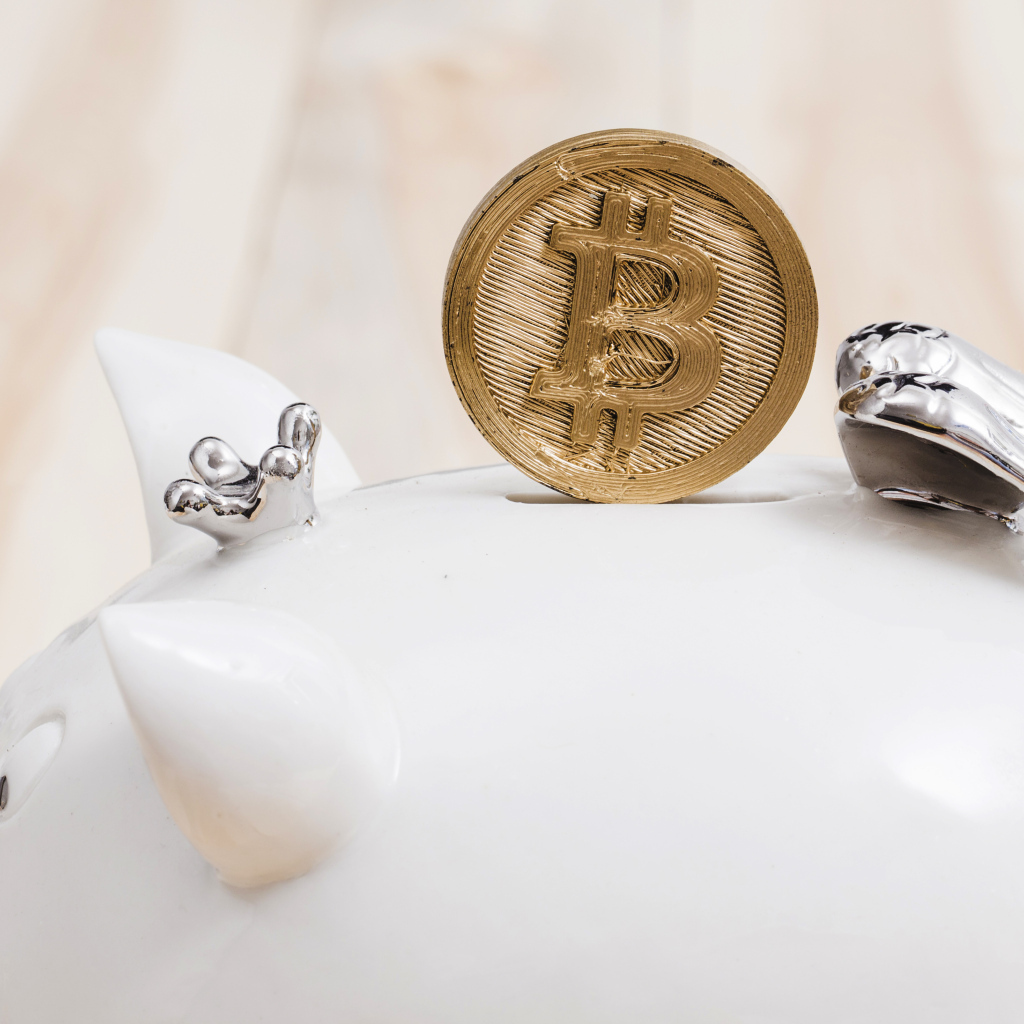 Золотая монета биткоин с копилкой