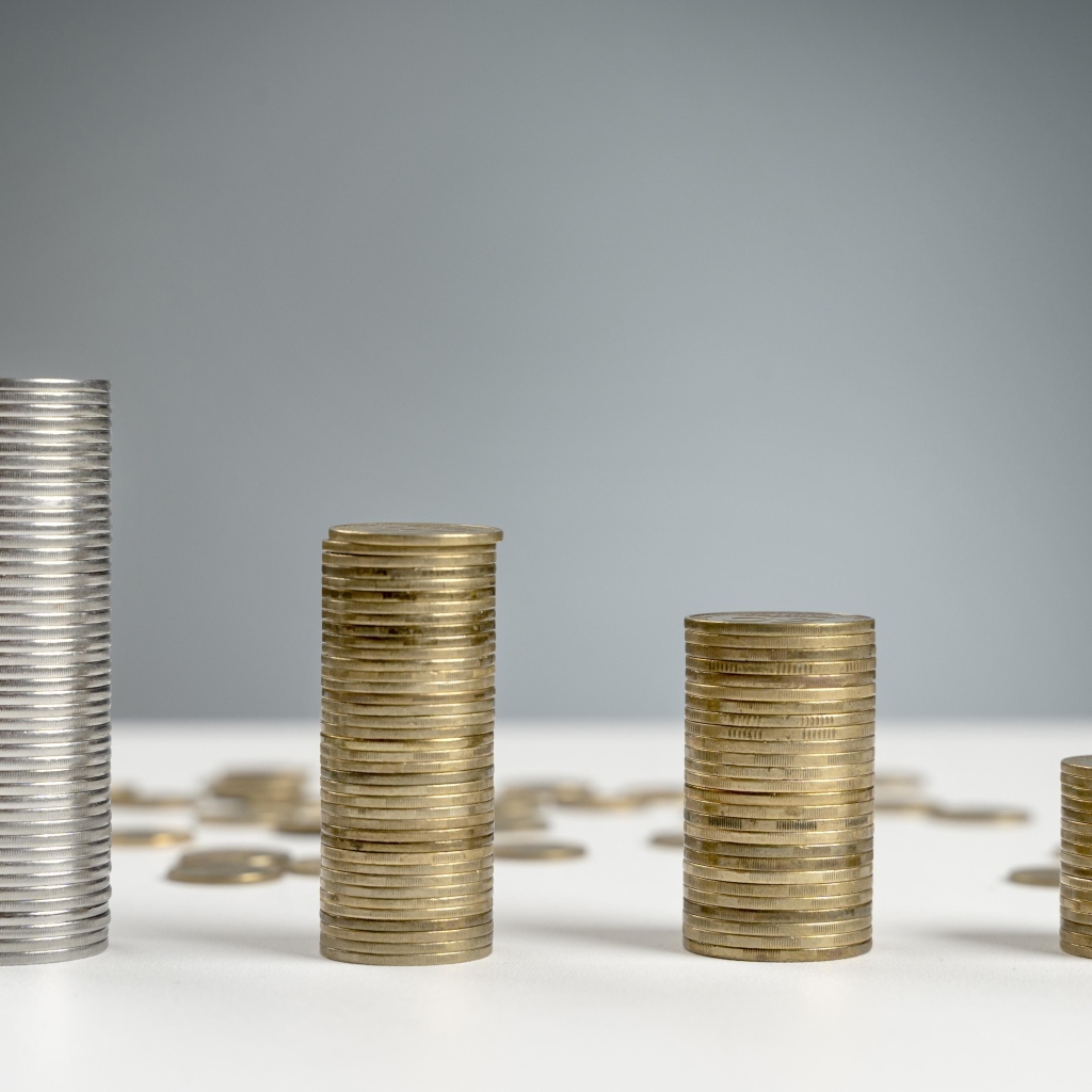 Стопки монет на сером фоне на столе