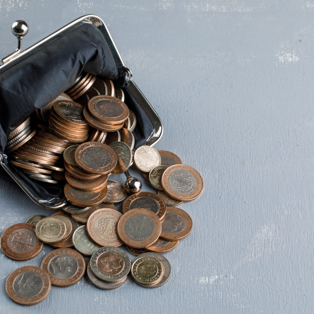 Кошелек с монетами на сером столе