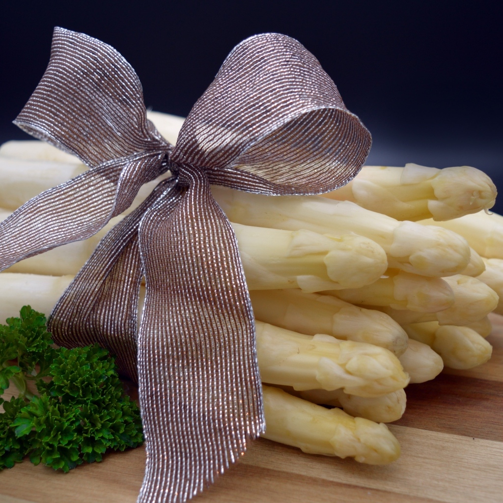 Спаржа с бантом на столе с петрушкой