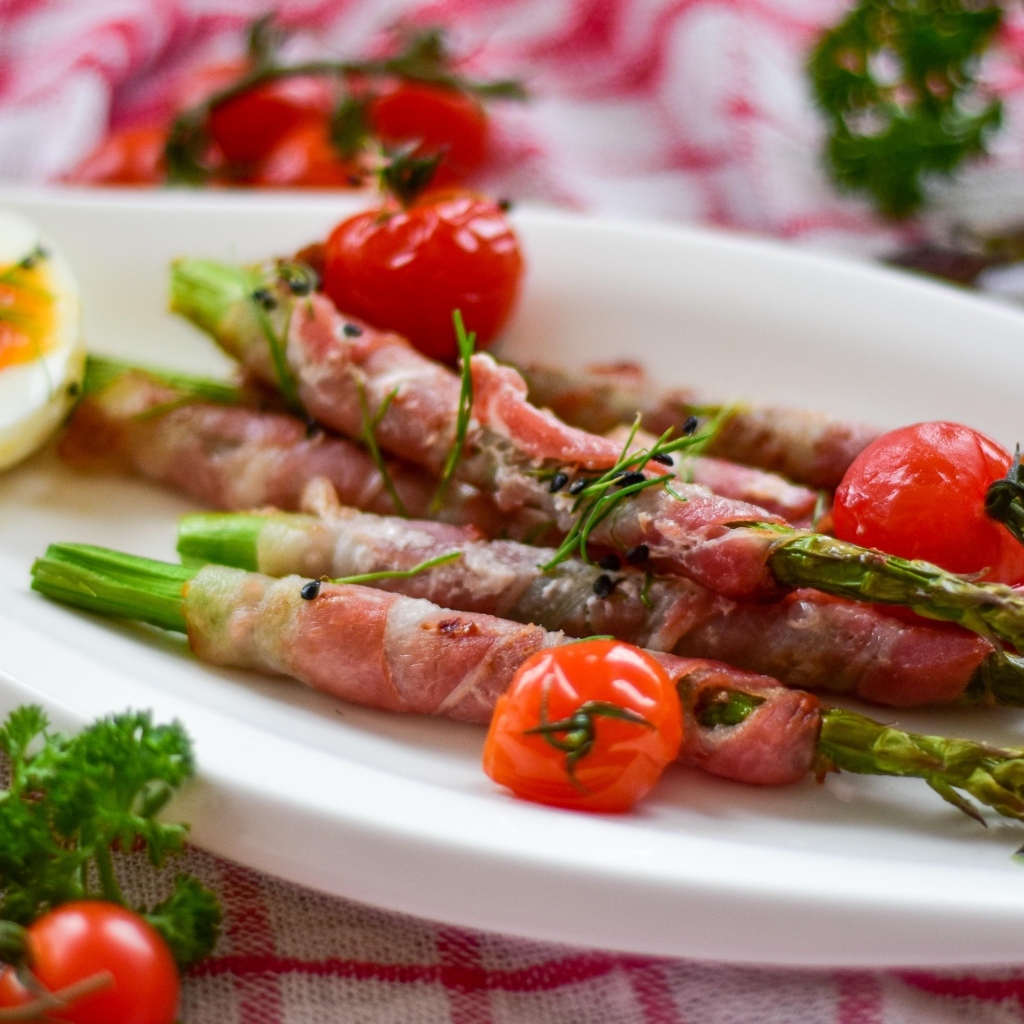 Спаржа в беконе на тарелке с вареными яйцами