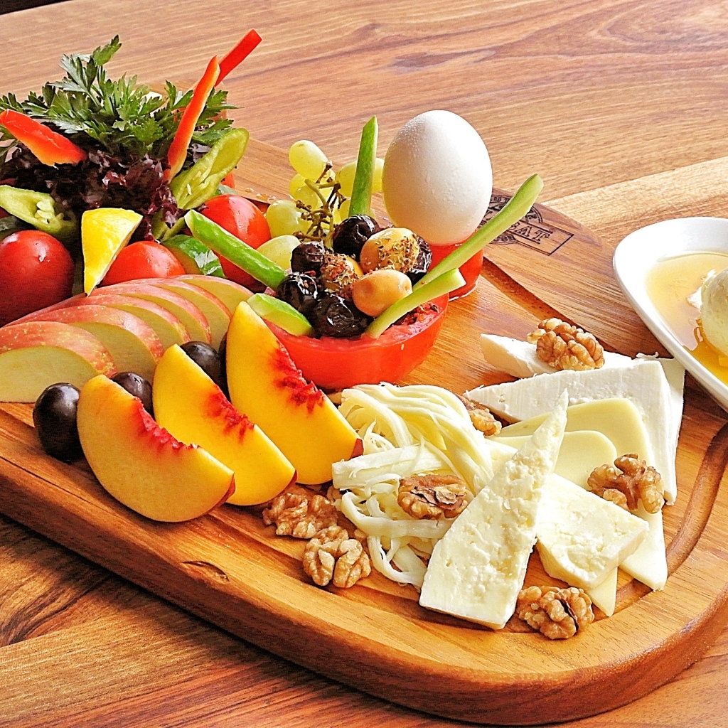 Сыр на доске с фруктами и салатом