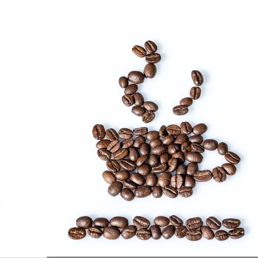 Чашка из кофейных зерен на белом столе