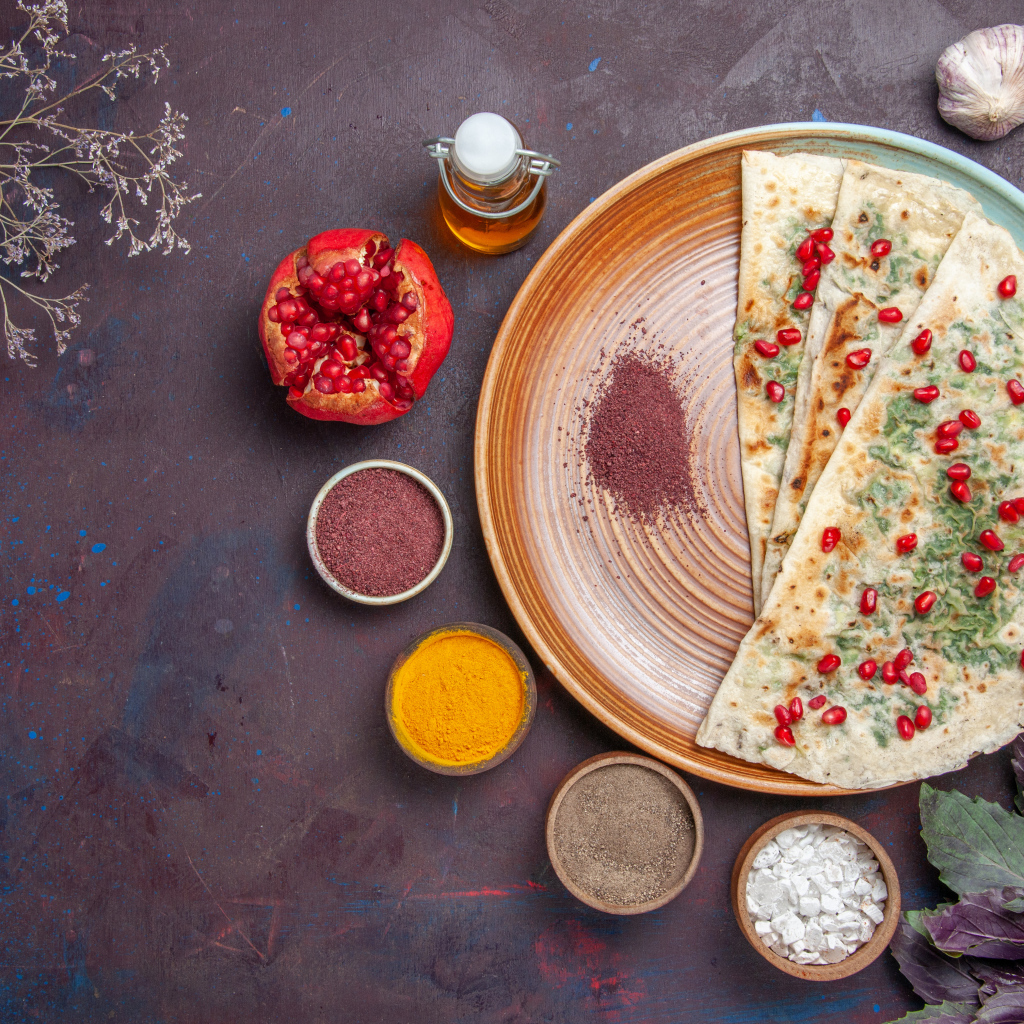 Лепешки на столе со специями и зеленью