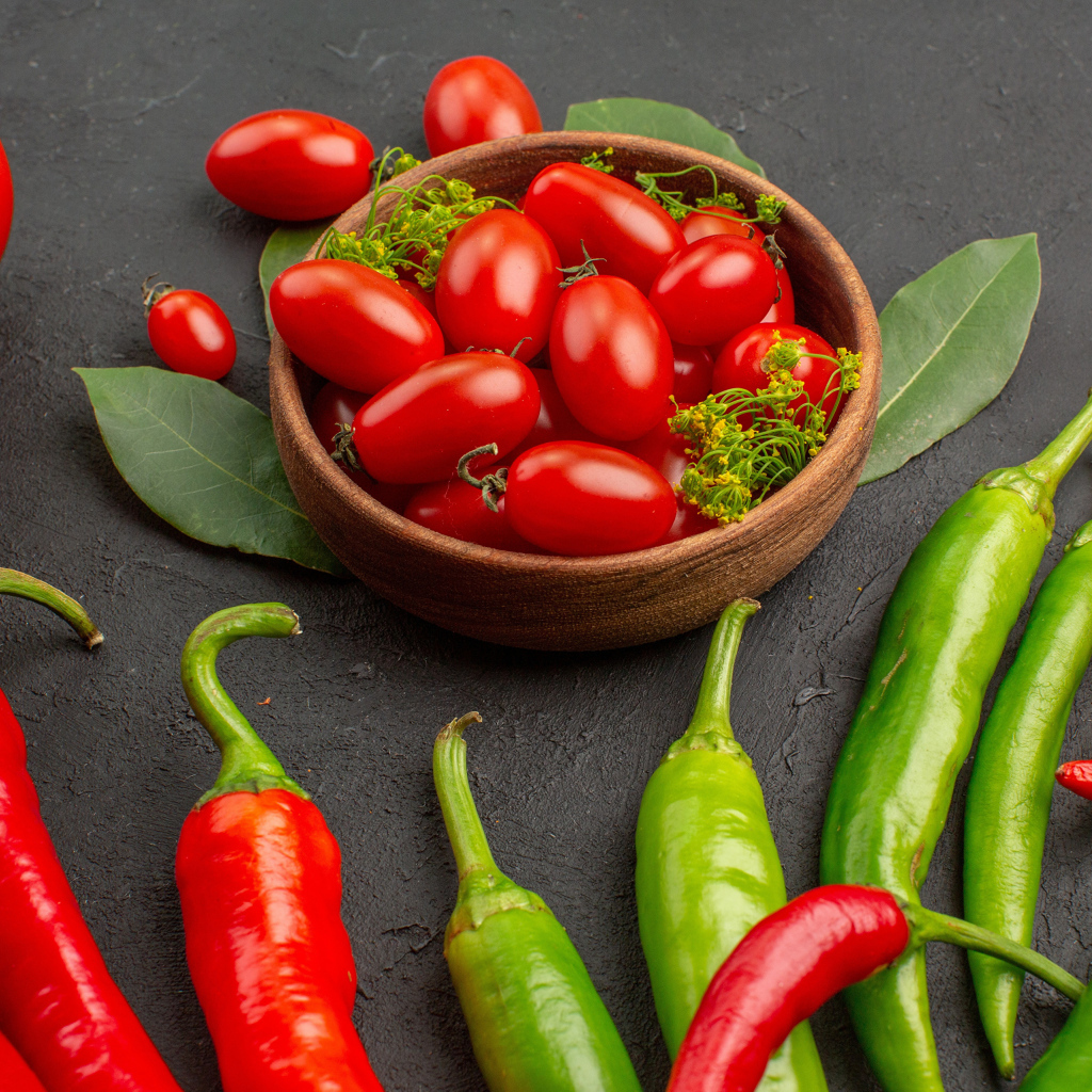 Свежие помидоры на столе с острым перцем