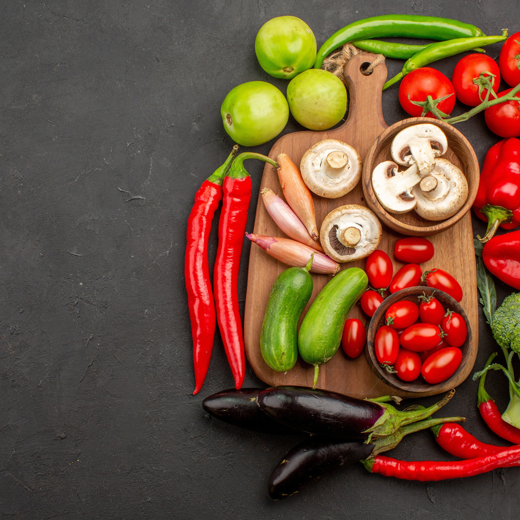 Свежие овощи на разделочной доске на столе