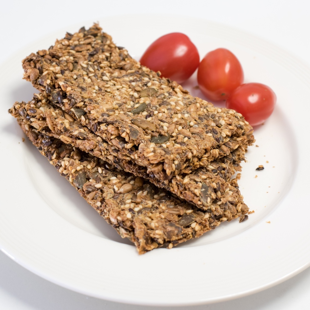 Полезны злаковые хлебцы на тарелке с помидорами