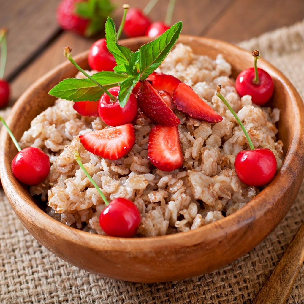 Овсяная каша с ягодами в деревянной миске