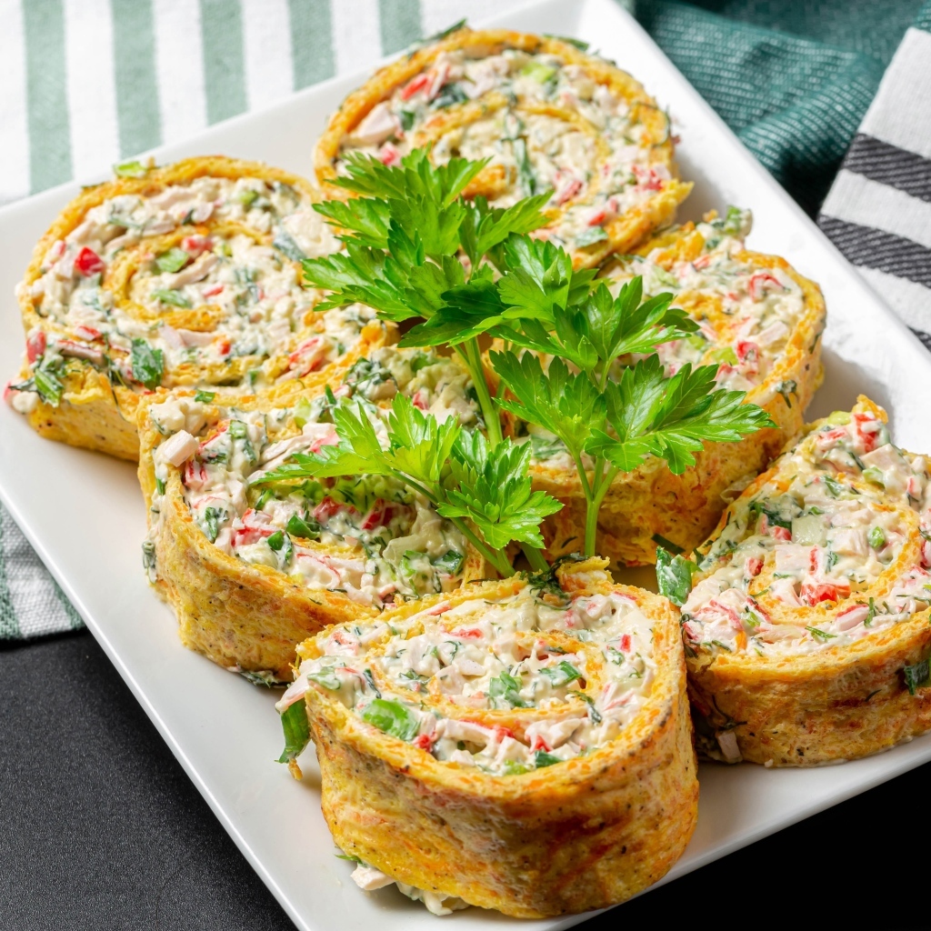 Рулет с омлета с начинкой на тарелке